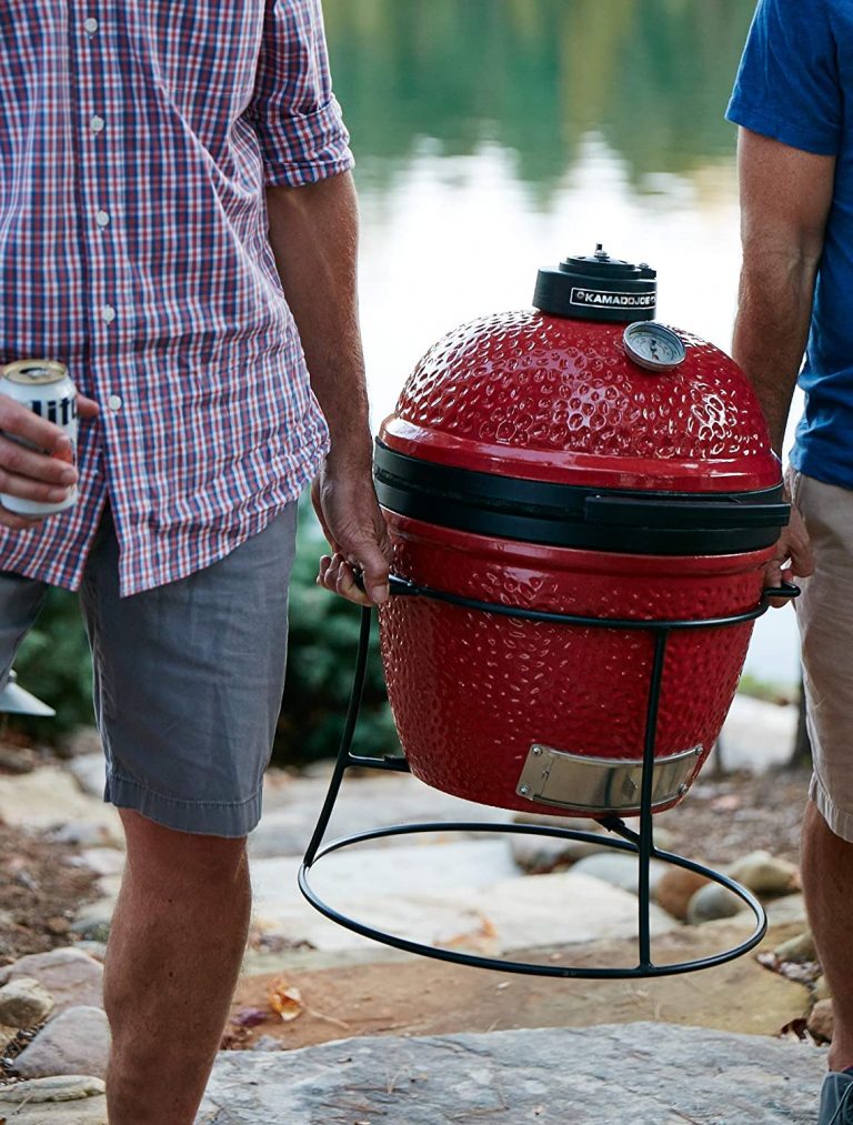 2 men carrying a Kamado Joe Jr. ceramic charcoal grill