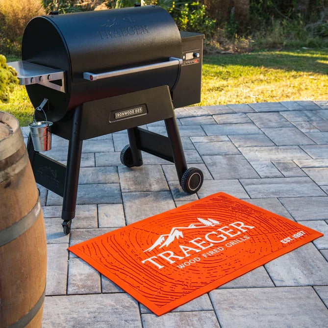 Traeger orange grill mat in front of a large grill