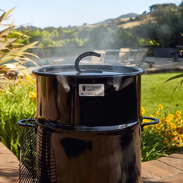 18.5" Classic Pit Barrel Cooker with lid closed and smoke pluming