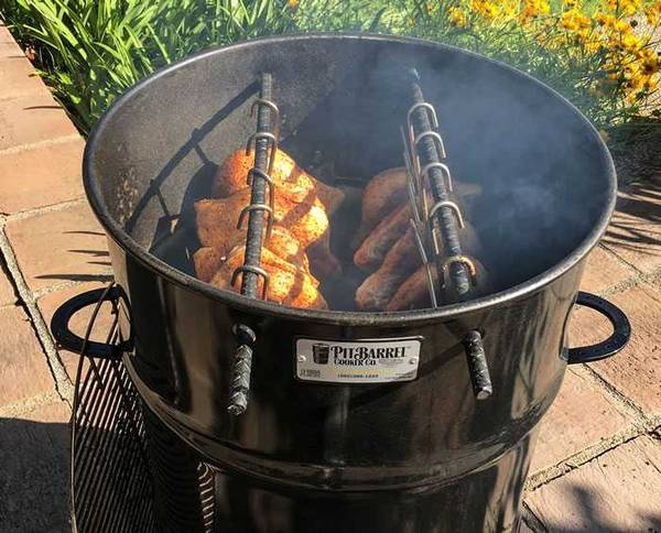 18.5" Classic Pit Barrel Cooker with cooking meats hanging from cooking bars